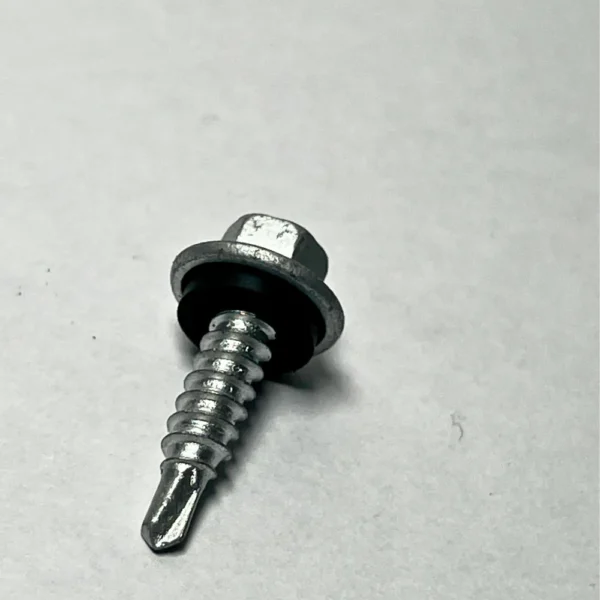 Primer plano de la cabeza hexagonal y el fijador cónico de un tornillo autoperforante de acero.