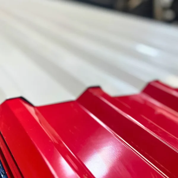 Primer plano del perfil y acabado brillante de una teja de acero trapezoidales prepintado en color rojo.